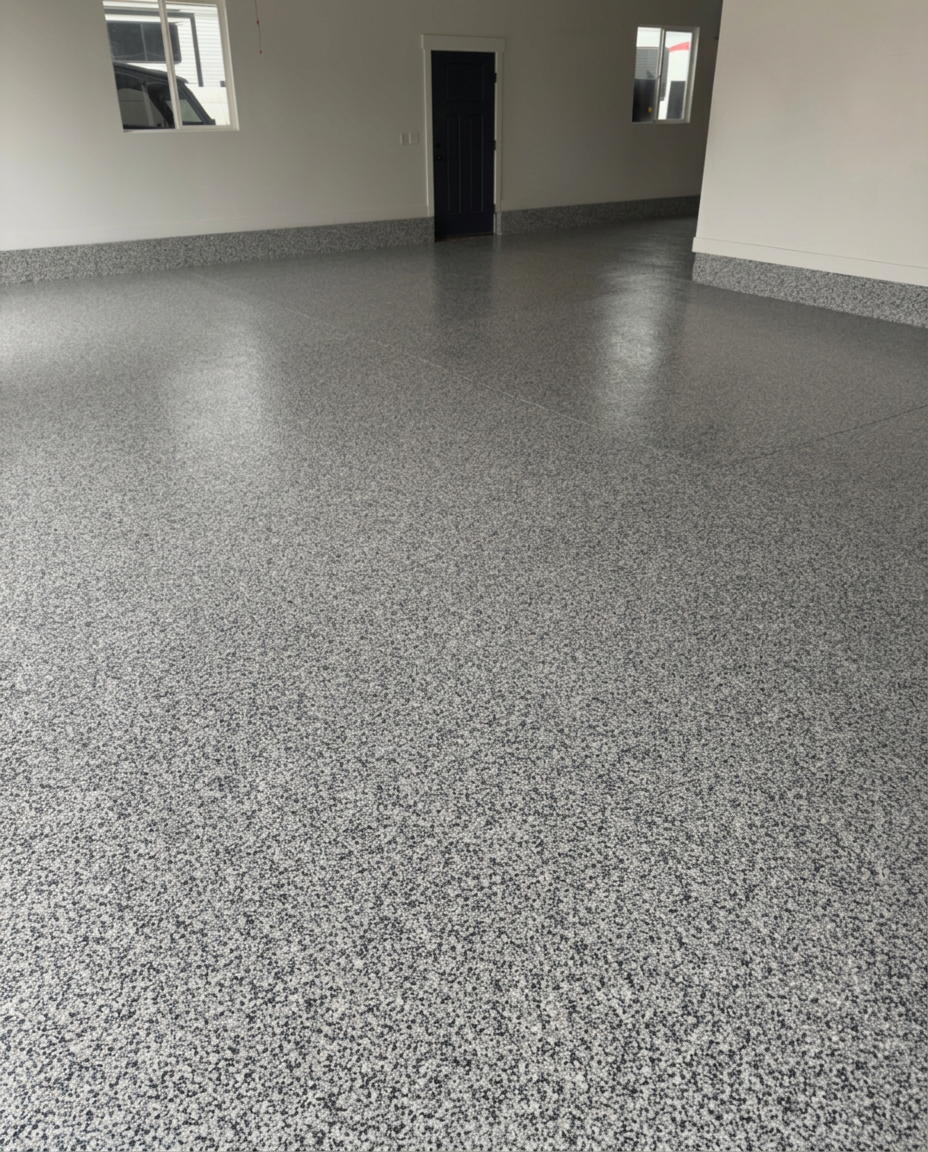 Dark grey flake garage floor with door open to the driveway