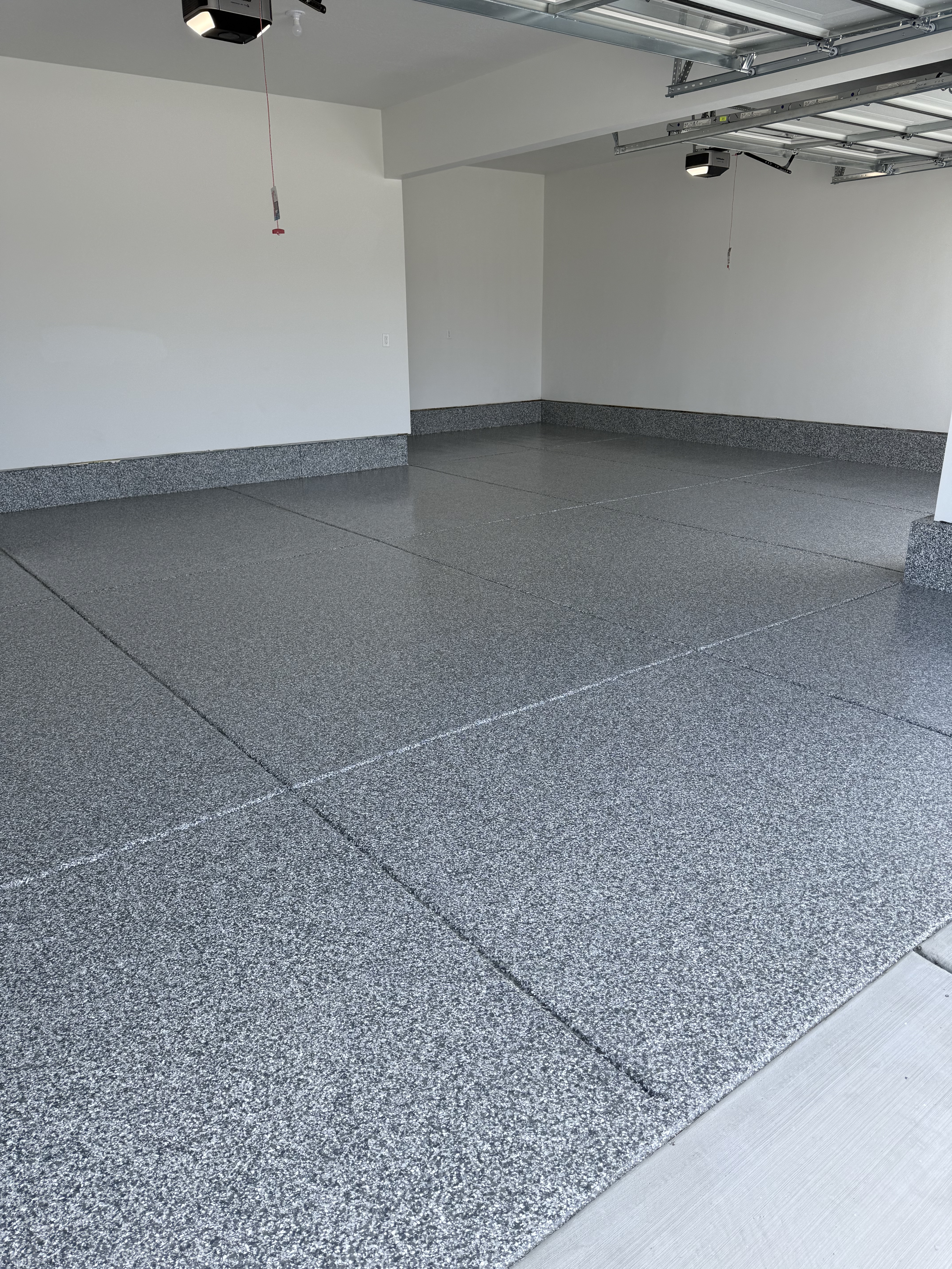 Three-car garage with polyaspartic flake floor overlooking the Utah mountains